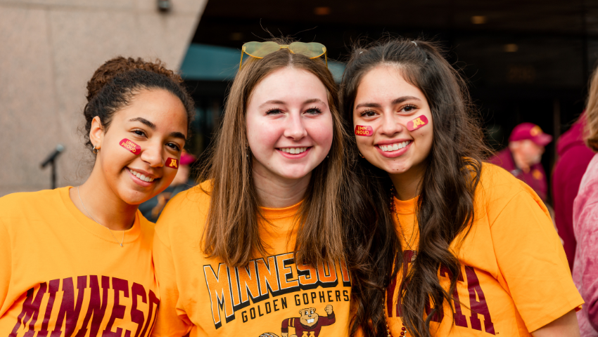Group of friends smiling and wearing Gopher gear at Ski-U-Mania